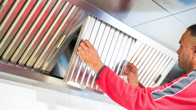 Dolmans medewerker verwijdert luik van vetkanaal voor reiniging